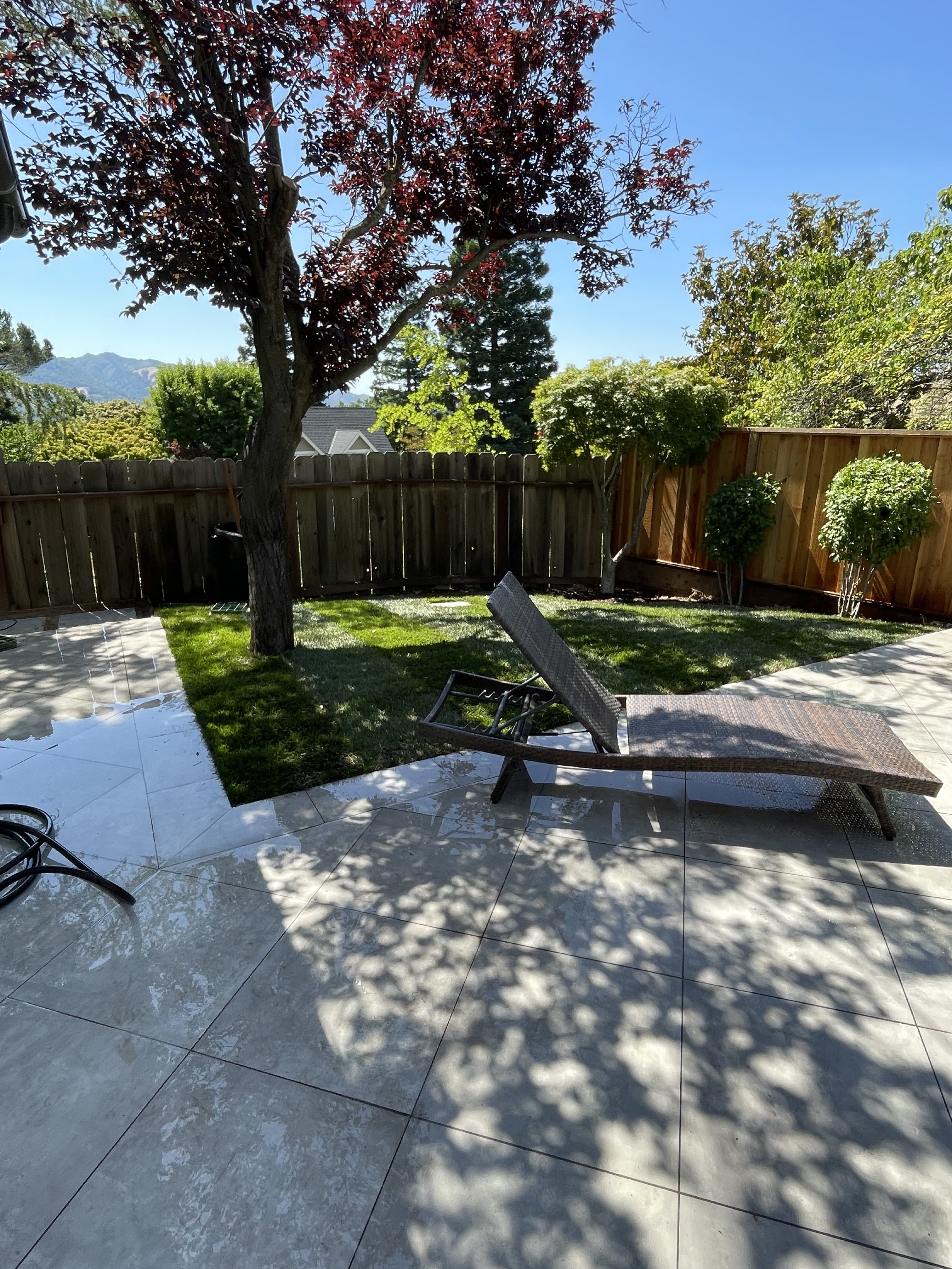 Completed backyard patio with large format tile and mountain views by BlackHawk Landscaping