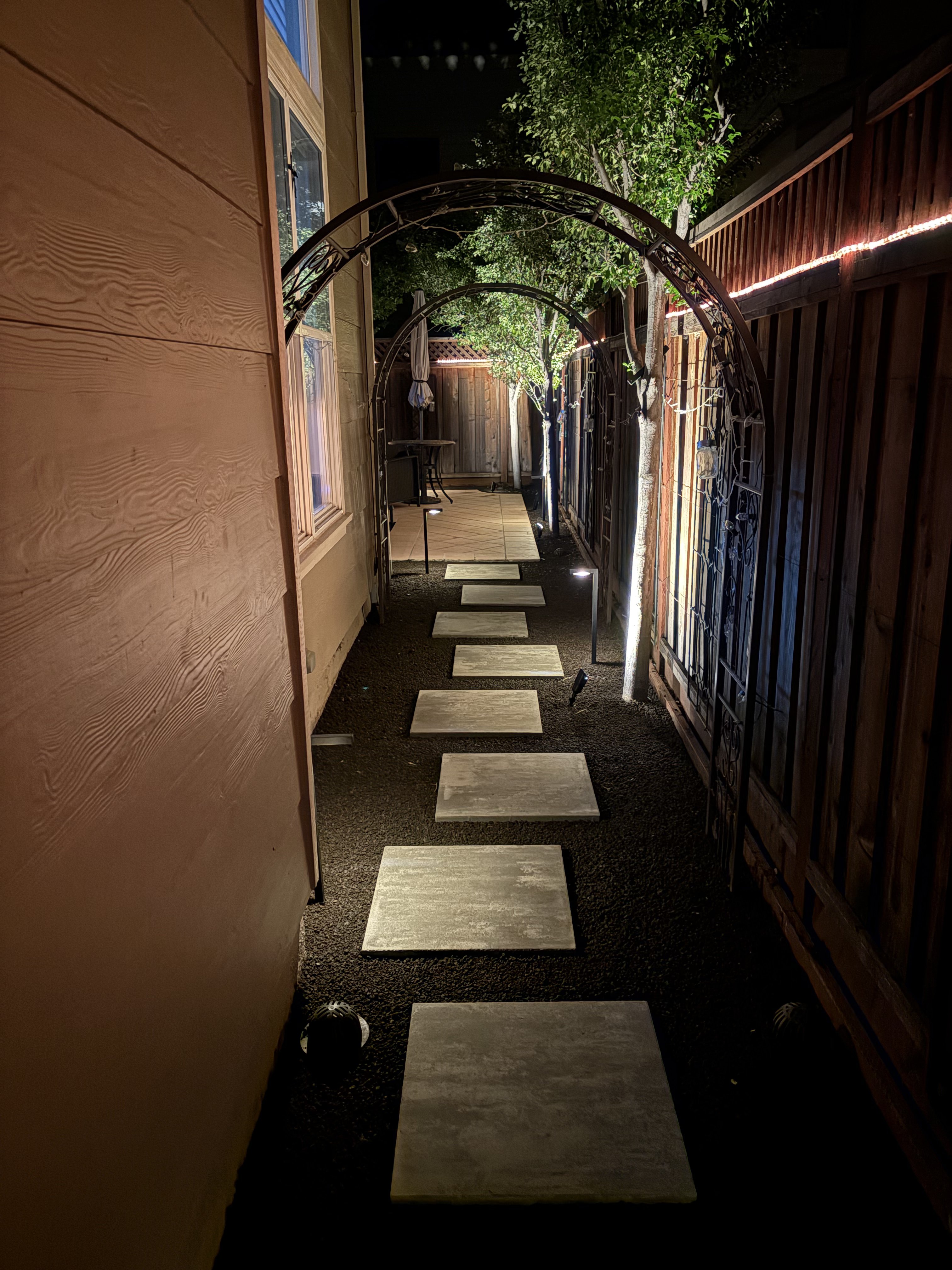 Illuminated stepping stone pathway with landscape lighting by BlackHawk Landscaping