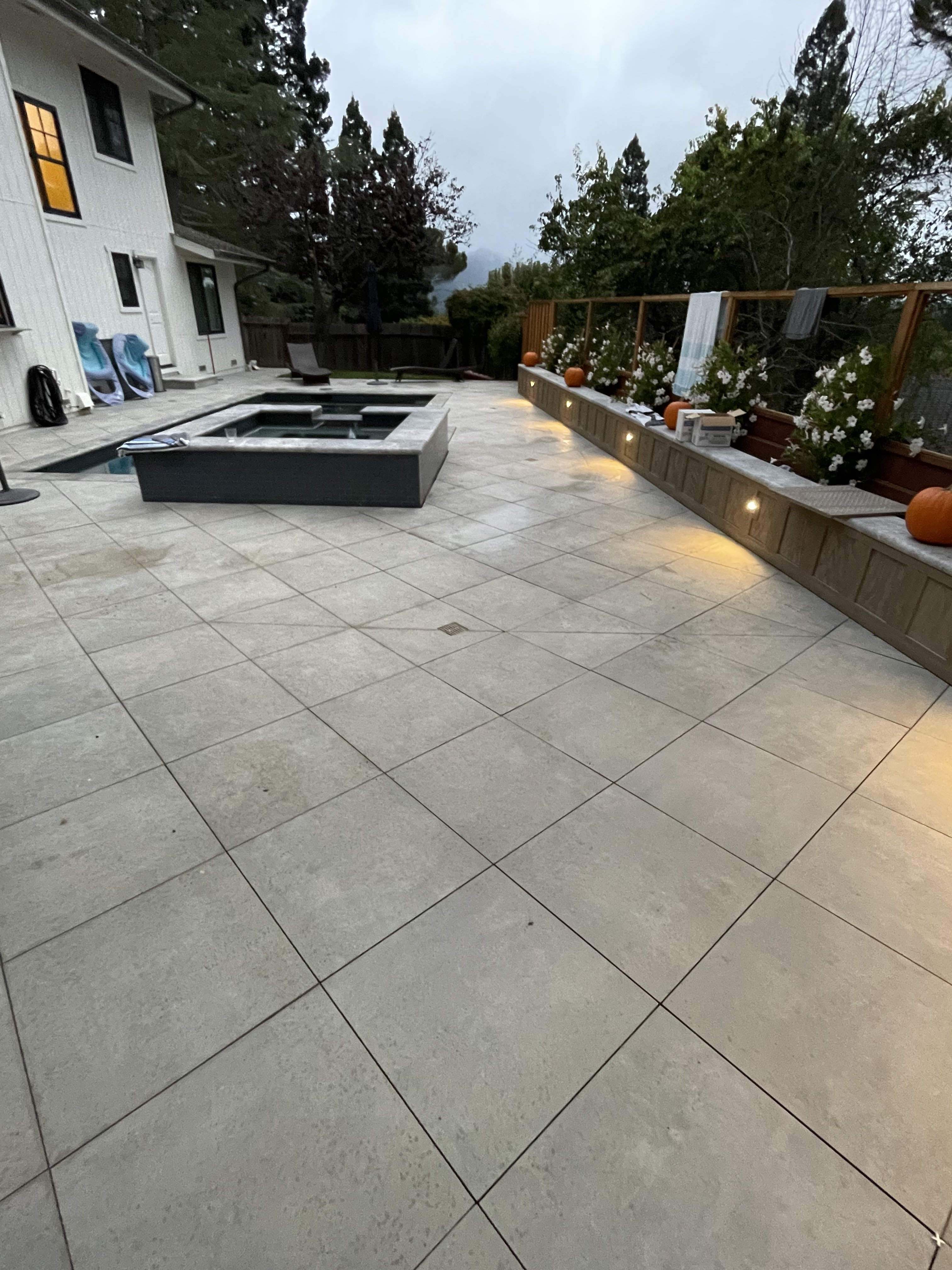 Evening patio with spa and landscape lighting by BlackHawk Landscaping