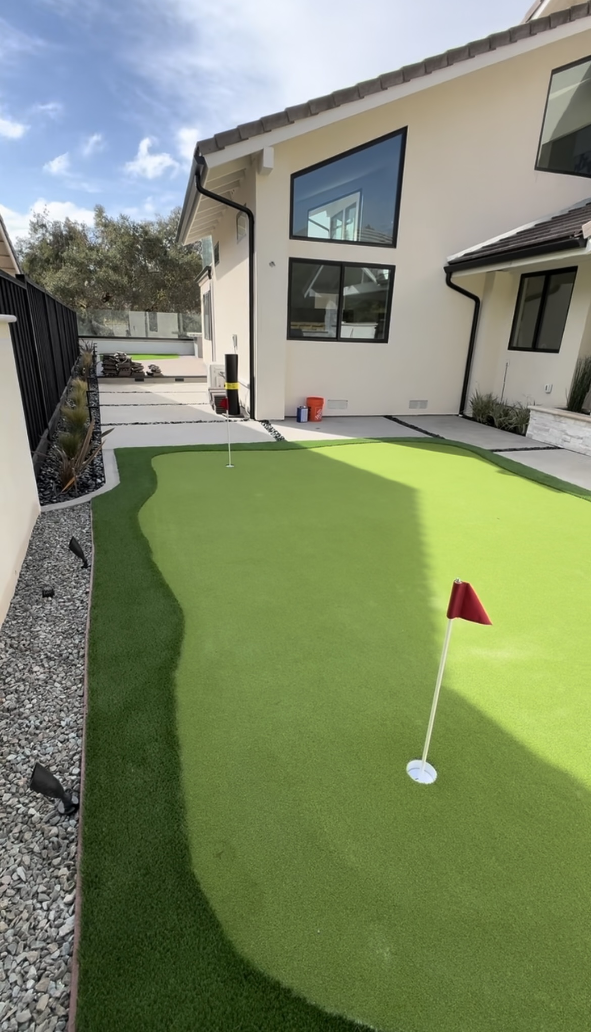 Putting green with artificial turf side yard by BlackHawk Landscaping