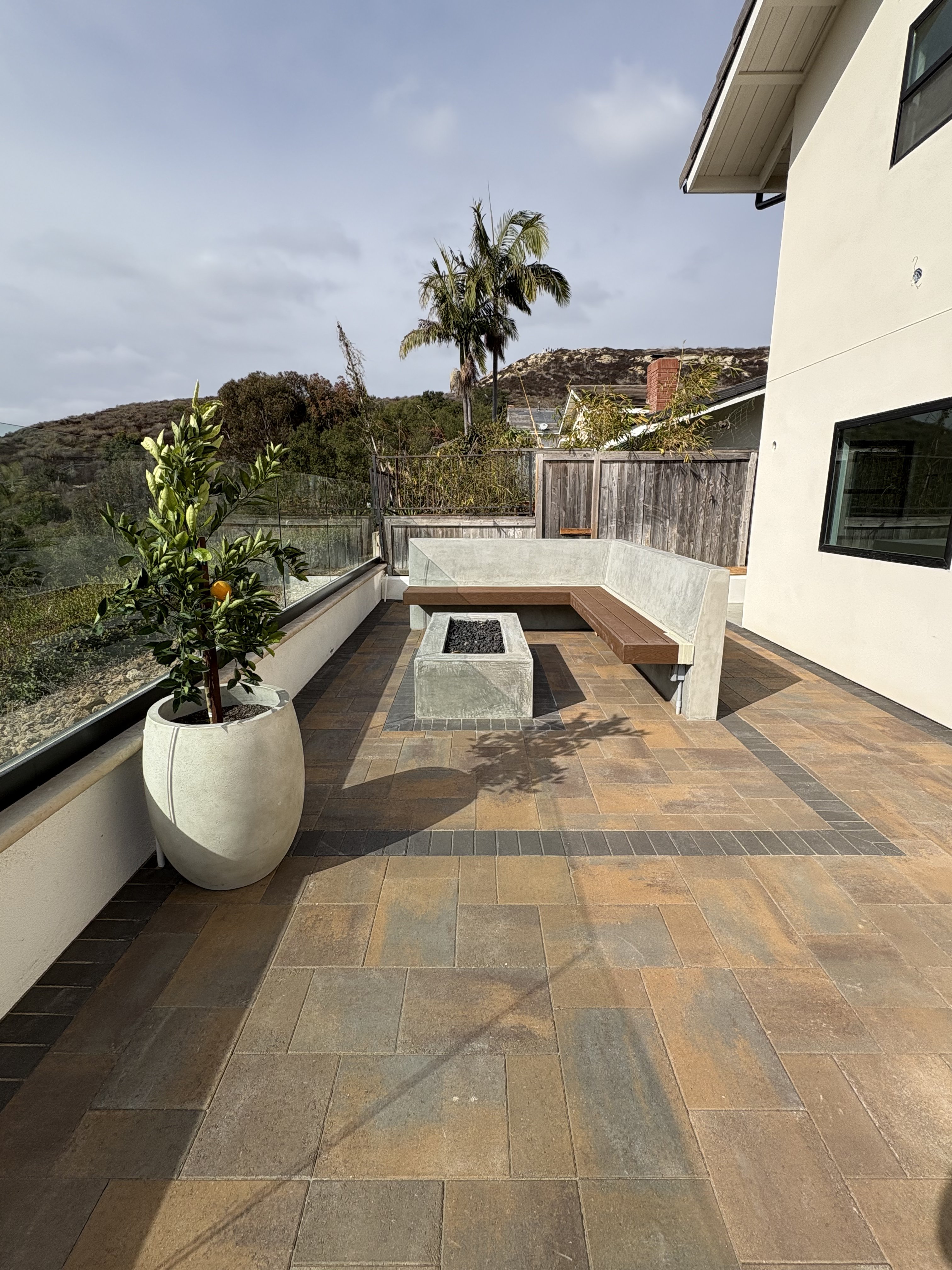 Rooftop terrace with fire pit and built-in seating by BlackHawk Landscaping